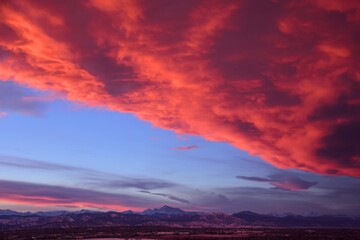 dramatic front of clouds moving in  across long's peak and the front range  at sunset, as seen from broomfield, colorado 