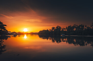 Fototapeta na wymiar sunset at coast of the river. Nature landscape and reflection sunset.