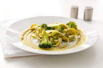 Plate with tasty pasta and vegetables on table