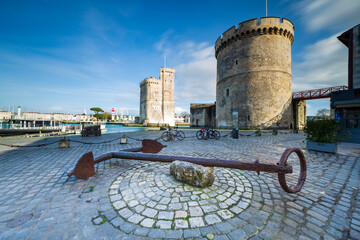 Anchor on the Place de la Chaîne in the old harbor of La Rochelle, France. With the Tour de la Chaine on the right side and the Tour Saint-Nicolas, Nouvelle Aquitaine region, Charente-Maritime, France