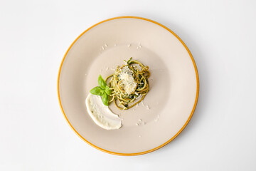 Plate with tasty pasta and spinach on white background