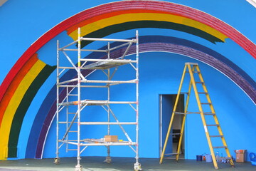 Rainbow being painted on blue wall