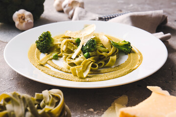 Plate with tasty pasta and vegetables on table