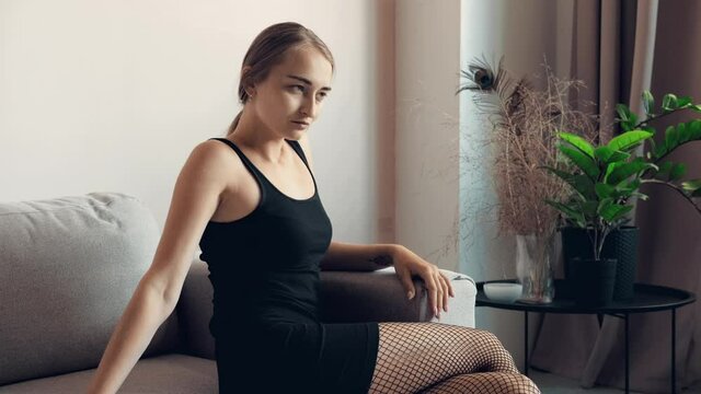 Woman sitting on couch in front of the window