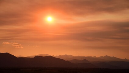 fiery sunset over the front range of the colorado mountains due to the smoke from  the western forest fires, as seen from broomfield, colorado