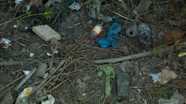 Rubbish littered. Panning shot of trash poorly disposed.