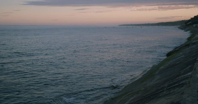 small seawaves hit breakwater at dawn