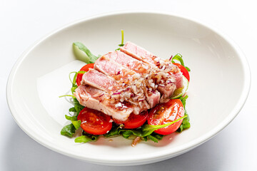 tuna fillet with salad on white plate