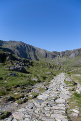 Fototapeta na wymiar Stone mountain path trail at Cwm Idwal mountains, part of Snowdonia National Park, on a sunny day