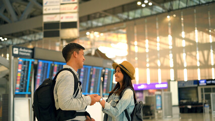 Couple Asian people walking in airport terminal waiting for  flight boarding to travel by air