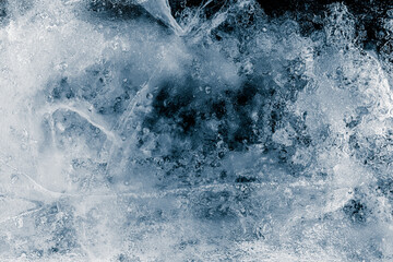 Transparent ice texture background. Textured frosty surface of ice blocks with cracks against black.
