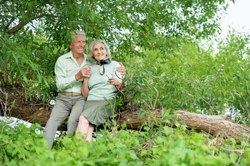 Portrait of happy senior woman and man hugging in park