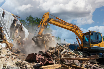 Process of demolition of old building dismantling. Excavator breaking house. Destruction of...