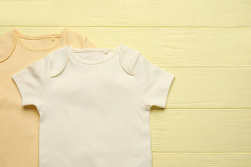 Baby clothes on color wooden background