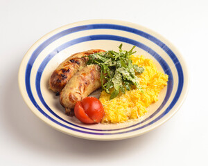 Risotto with pork sausages with cherry tomatoes and parsley on a plate. Italian cuisine concept