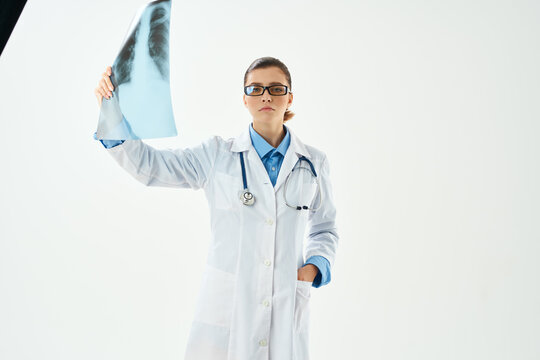woman radiologist in lab coat looking at x-ray diagnostics hospital
