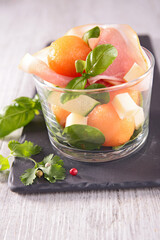 melon salad with prosciutto ham,  cheese and basil
