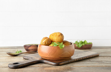Bowl with tasty baked potato on table