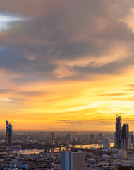 Fototapeta na wymiar Bangkok, thailand - Jul 02, 2021 : Aerial view of Bangkok city Overlooking Skyscrapers and the Bridge crosses the Chao Phraya river with bright glowing lights at dusk. Selective focus.