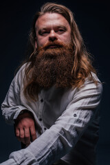 Close up portrait of handsome manly guy with beard posing in studio on a isolated background.