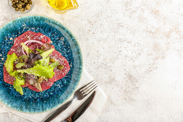 Plate with tasty veal carpaccio on light background