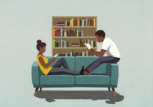 Couple reading books on living room sofa
