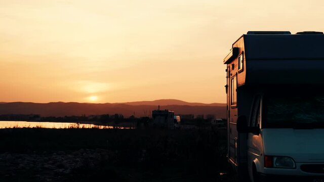 Coastal landscape with caravan wild camping on beach at sunset. Capi Corb, Mediterranean coast of Spain. Holidays, traveling with motorhome.