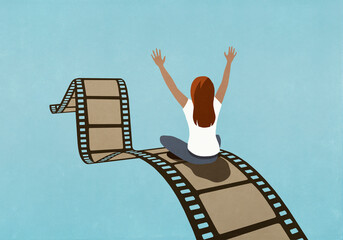 Excited woman riding movie film reel
