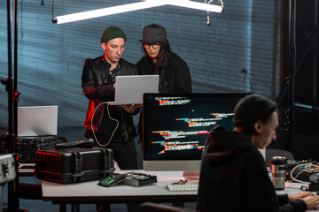 Two young programmers or hackers using laptop