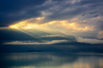 Storm Clouds with Sunlight over Brissago Islands on Alpine Lake Maggiore with Mountain in Ticino, Switzerland.