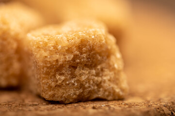 Pieces of brown cane sugar on a wooden table. Close-up Selective focus.