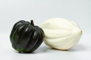 Two pumpkins white and dark green on a light background. Food photo