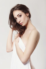 Fototapeta premium The beautiful girl is having a photo session in the studio in a night dress.