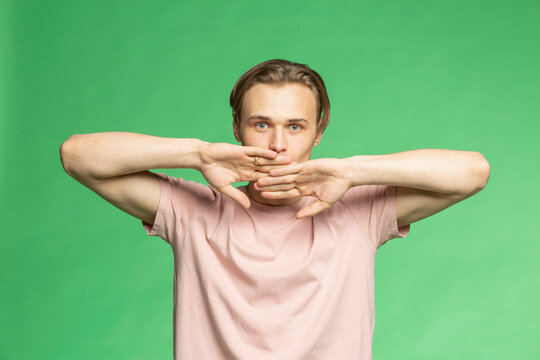 Studio portrait young man with hands covering face
