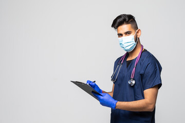 Young male doctor holding a clipboard and wearing a medical face mask isolated on white background
