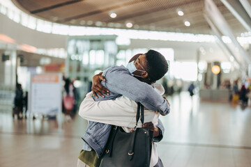 Woman getting warm welcome hug from man at airport