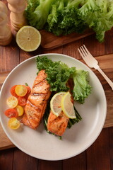Fried salmon steaks. Cooked salmon steak with pepper, herbs, lemon, garlic, olive oil and Brussels sprouts. Grilled fresh fish.