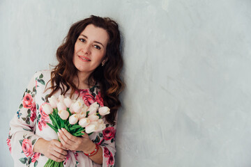 Portrait of a brunette woman in a summer dress with flowers