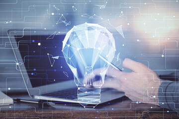 Double exposure of man's hands holding and using a digital device and bulb hologram drawing. Idea concept.