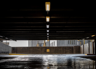 Abandoned multi storey carpark with collapsed roof. Flooding on concrete floor, pools of water on level ten 10. Dark and moody eerie atmosphere.