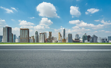 Side view of asphalt road with modern city skyline