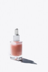 Face Serum in crystal  bottle on white background with hard shadow. Modern Skin care concept.