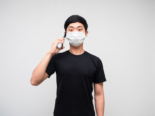 Asian man wearing mask talking with mobile phone on white background