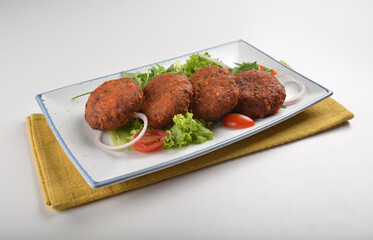 deep fried golden potato cake ball with greens salad in white background asian Indian appetiser halal menu