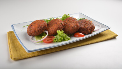 deep fried golden potato cake ball with greens salad in white background asian Indian appetiser halal menu
