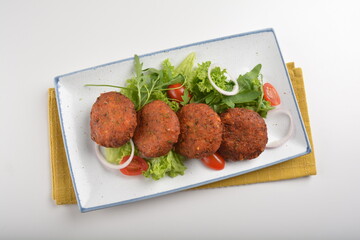 deep fried golden potato cake ball with greens salad in white background asian Indian appetiser halal menu