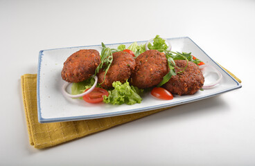 deep fried golden potato cake ball with greens salad in white background asian Indian appetiser halal menu