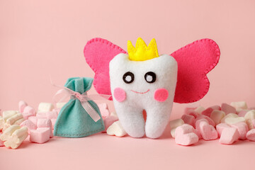 Cute toy for Tooth Fairy Day as funny smiling cartoon character of tooth fairy with crown, wings on pink background, copy space flyer, concept children milk toothless, funny toy, handmade felt diy - 443575586
