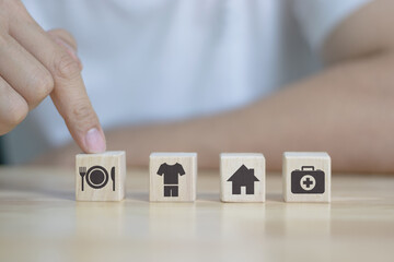 human hand placing cube with food Clothing, housing, medicine, four basic human needs concept.