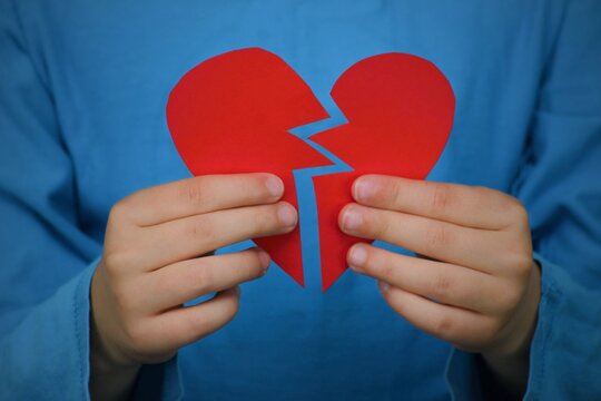 A Person Holds Two Halves Of A Heart That Fit Together. And What About A Broken Heart? Relationships And Marriages Often Fall Apart.